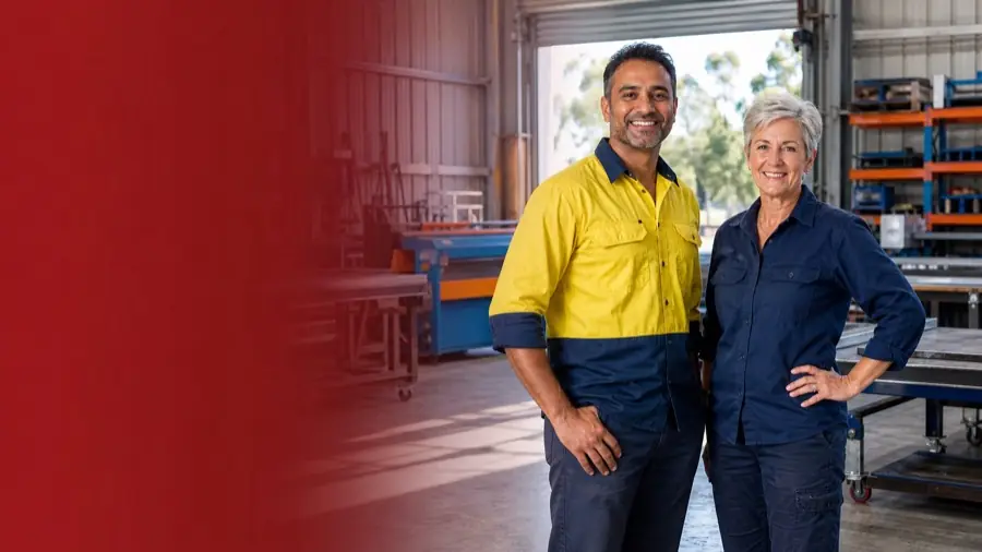 Two Australian manufacturing owners smiling in their light-industrial workshop
